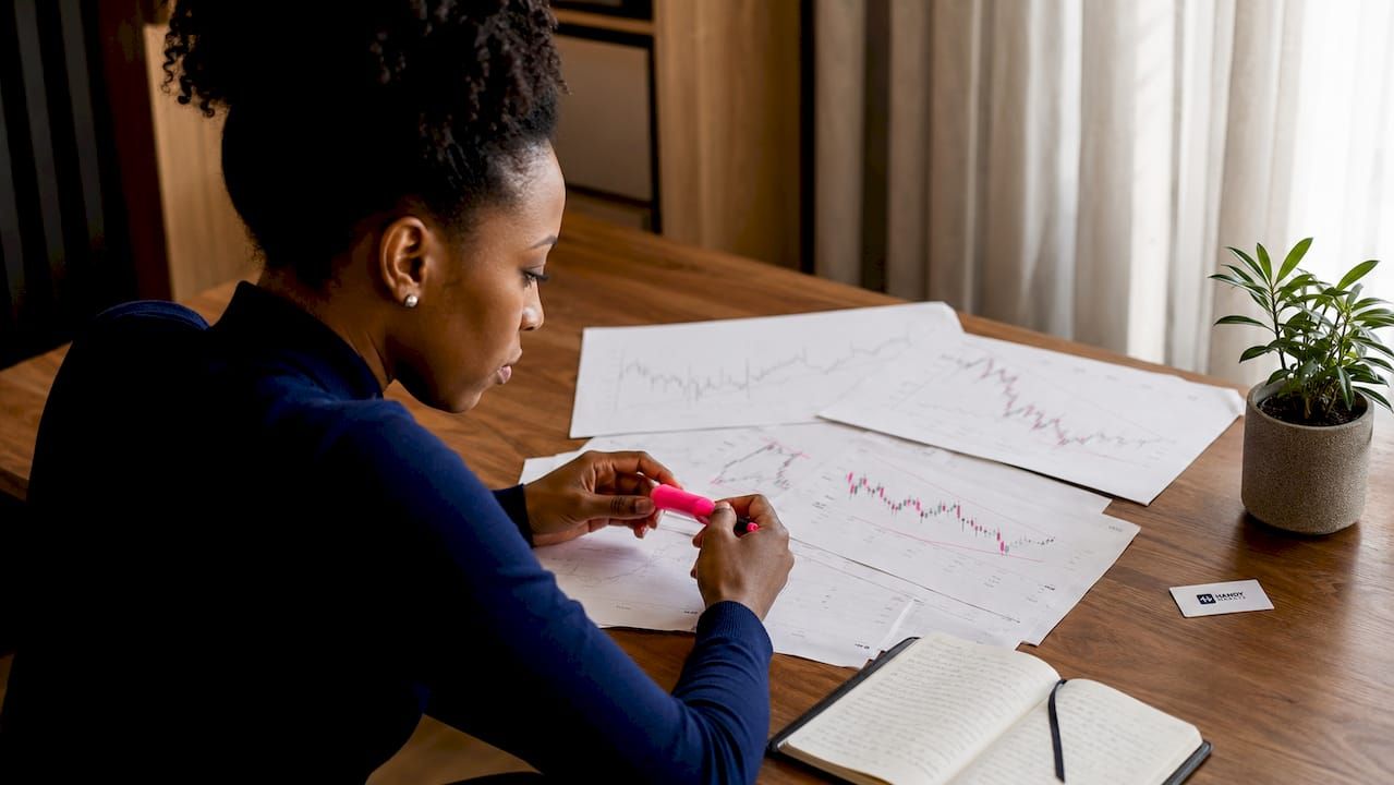Close-up of hands marking technical price charts