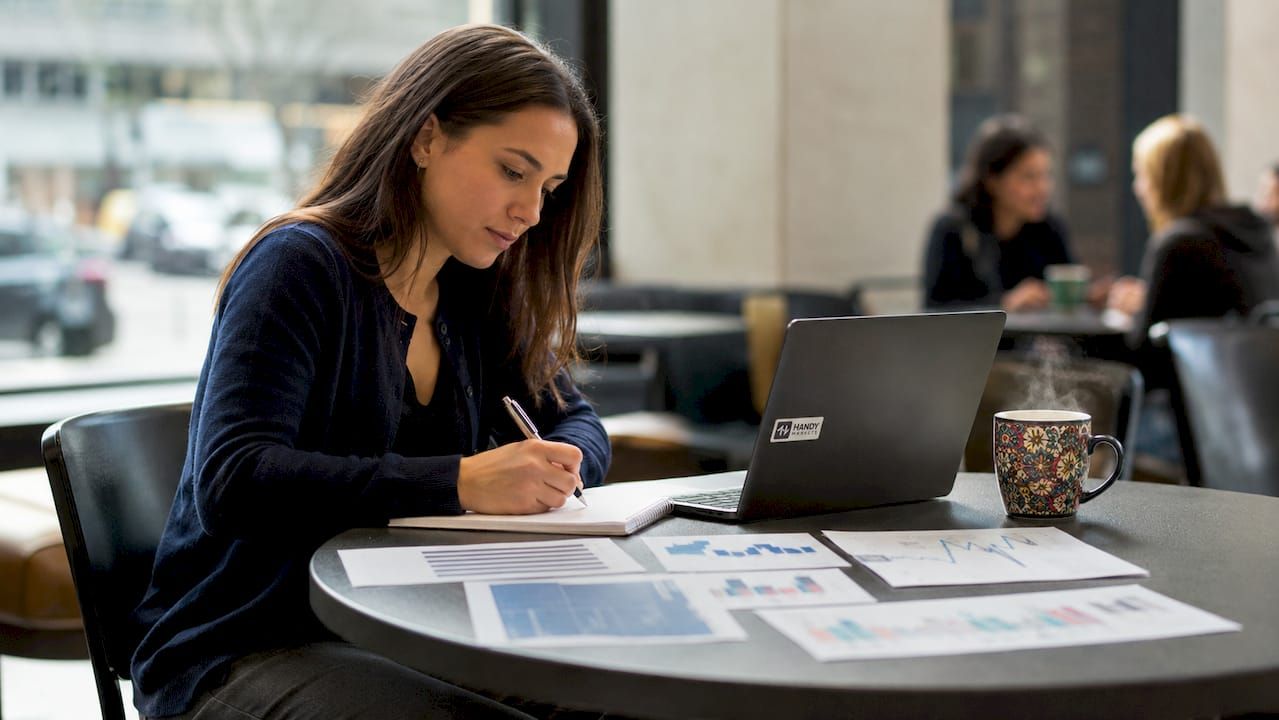 Hands writing notes on futures contract pricing